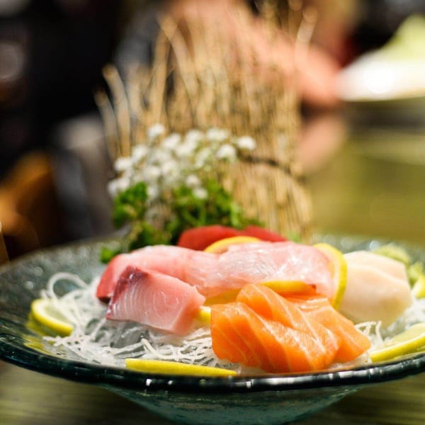 A platter of Kirin Asian Cuisine & Sushi sashimi with salmon, tuna, and lemon slices.