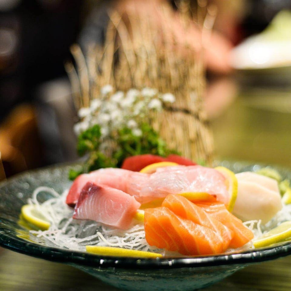 A platter of Kirin Asian Cuisine & Sushi sashimi with salmon, tuna, and lemon slices.